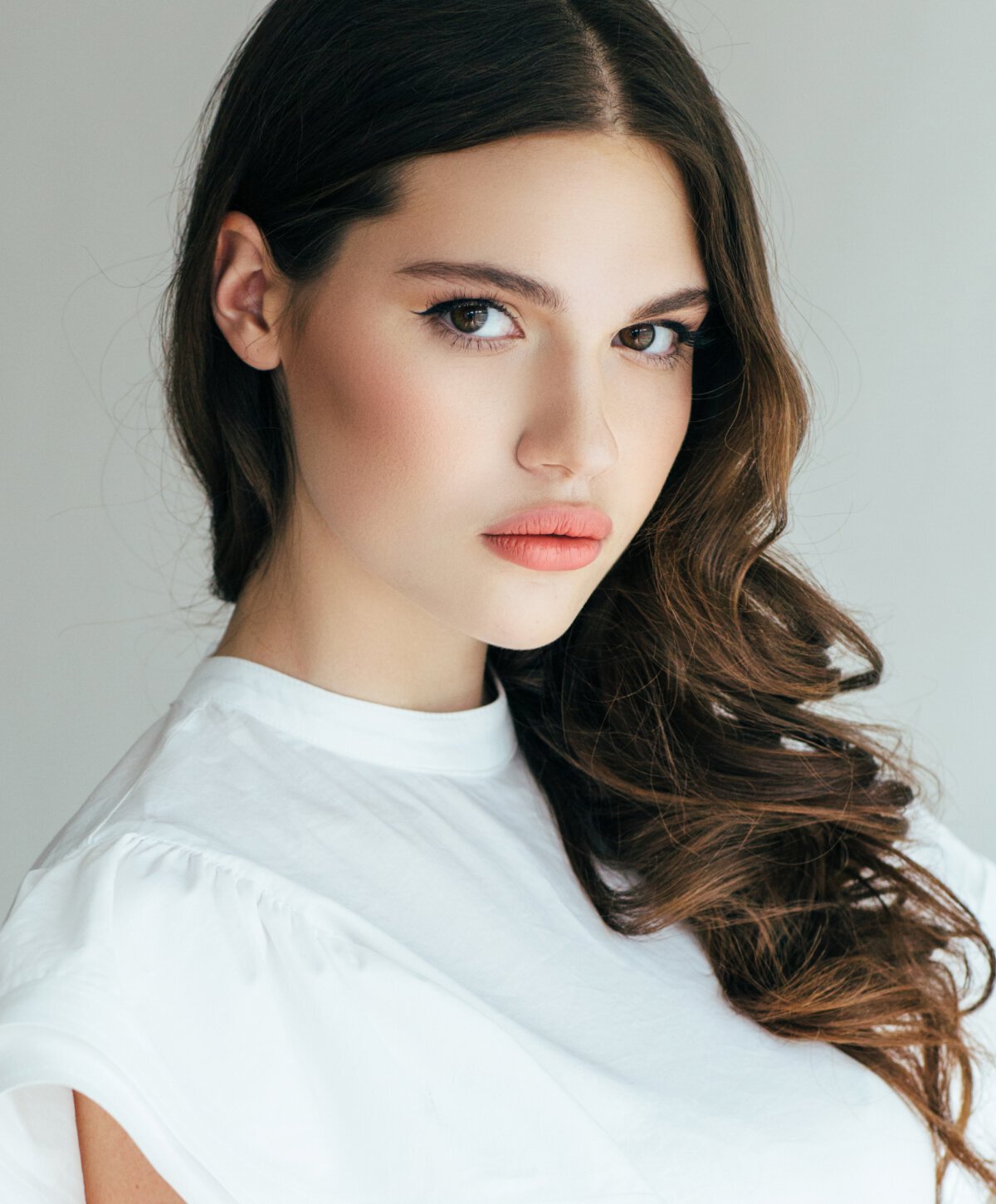 birmingham Rhinoplasty patient model with brown hair wearing a white blouse